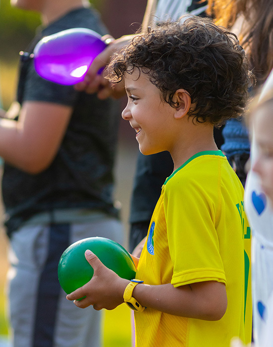 Water balloon toss, focused on boy wearing yellow holding