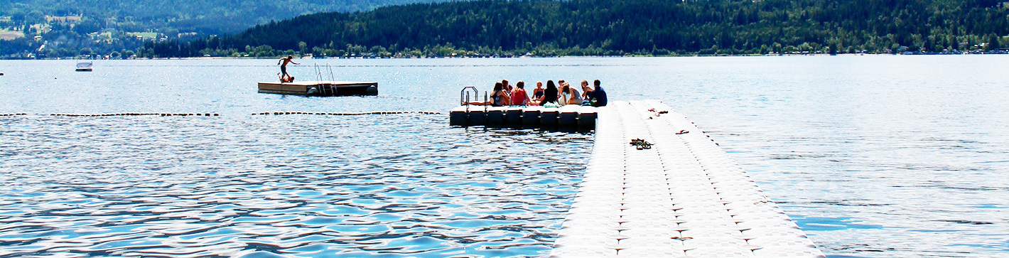 Dock on the water with campers sitting at the end